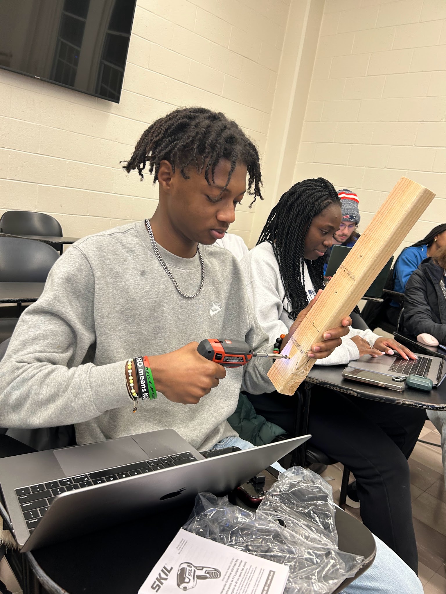 Student using the rechargeable screwdriver to drive a screw during first-use analysis.