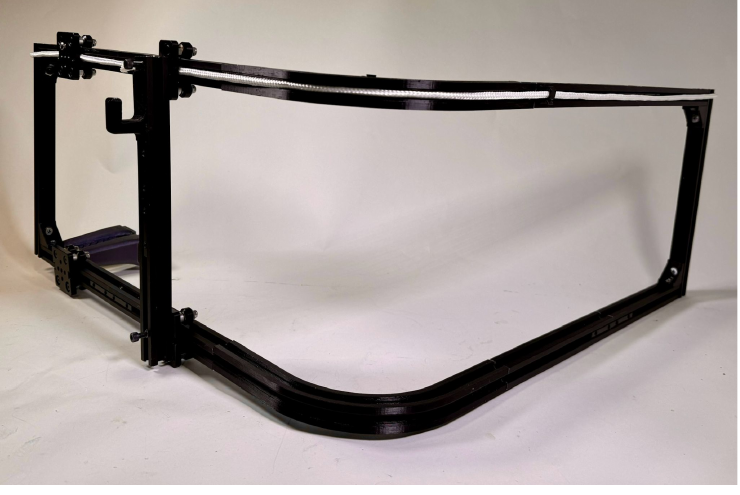 Angled photo of the finished storage prototype: black aluminum-extrusion frame with curved rail and printed connectors.