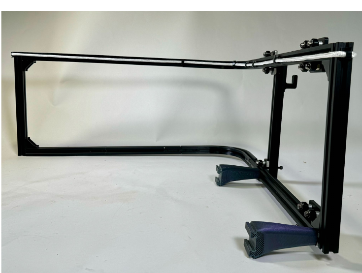 Side photo of the finished storage prototype showing the vertical arm, hooks, and wheelchair connection feet.